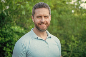 Portrait of happy handsome man smiling in blue tshirt natural background Portrait of happy handsome man smiling in blue tshirt natural background.